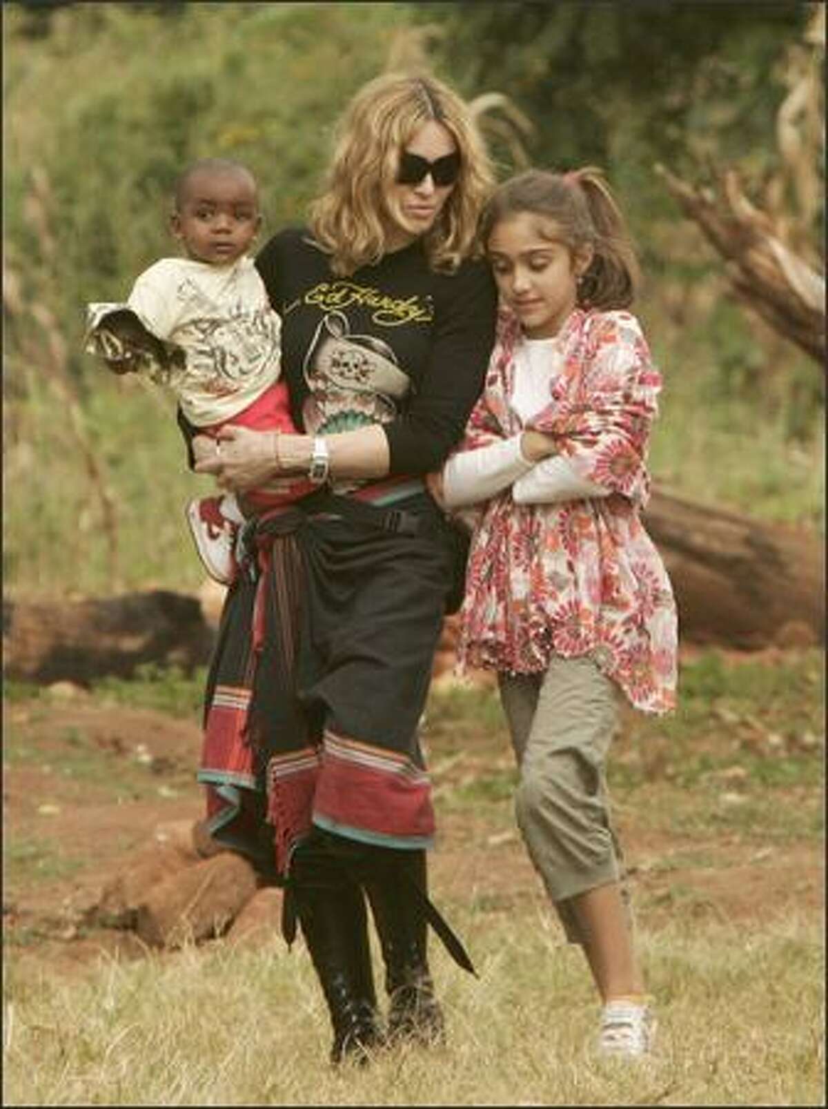 Madonna carries her adopted son David at the Home of Hope orphanage in Mchinji village, Malawi, April 17, 2007. Malawi police and stone-throwing school students blocked journalists from covering the pop star's visit to the orphanage, where the boy was due to meet his biological father. At right is Madonna's daughter Lourdes.