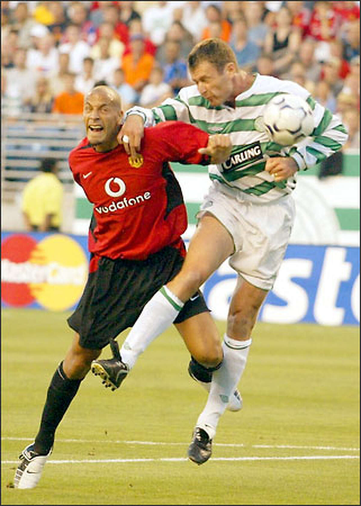 Manchester United's Rio Ferdinand, left, and Celtic's Chris Sutton battle for the ball during the first half.