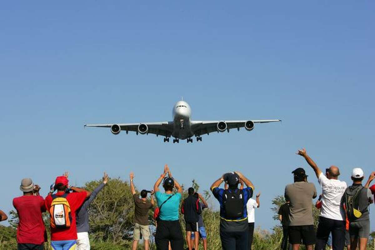 People watch as an Airbus A380 flies over the Indian ocean island of La Réunion during an exhibition flight before landing at the Roland-Garros airport on November 11, 2009 near the city of Saint-Denis-de-la-Réunion. The local airline company Air Austral has ordered two of the aircraft.