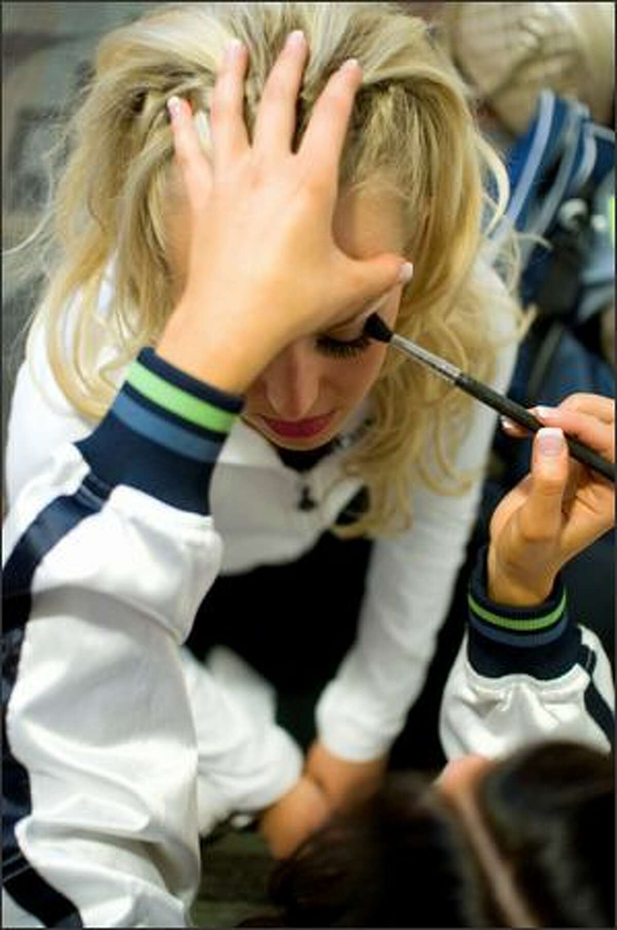 Brittany Wood gets her makeup done with a little help from friend Nicole Perry during final tryouts for the Sea Gals at Qwest Field. (Daniel Berman / Special to SeattlePI.com)