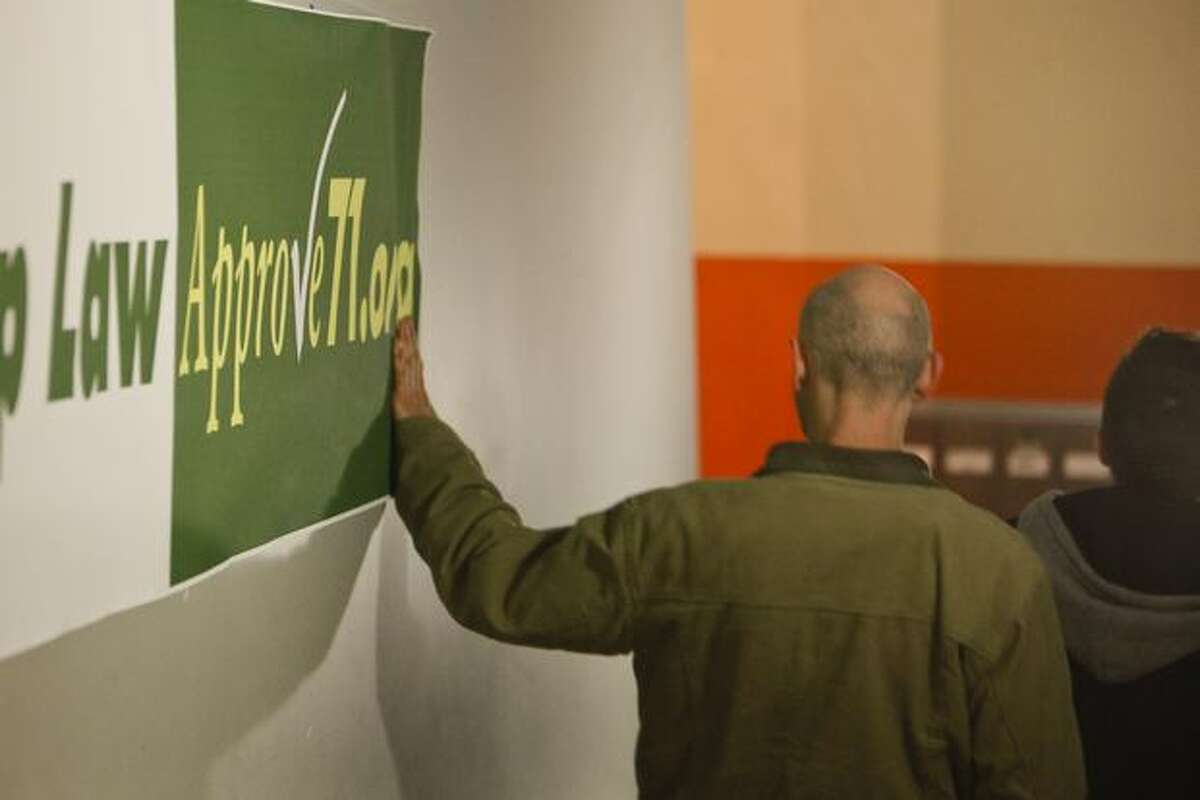 A man touches a sign at the approve Referendum 71 party.