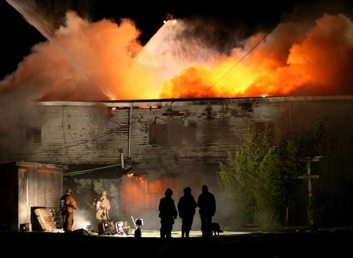 Firefighters from Shoreline, Kirkland, Bothell, Northshore, Seattle, and other departments battle a three-alarm fire in a vacant building on Aurora Avenue North in Shoreline. The fire, which burned for hours, shut down traffic on Aurora through the night.