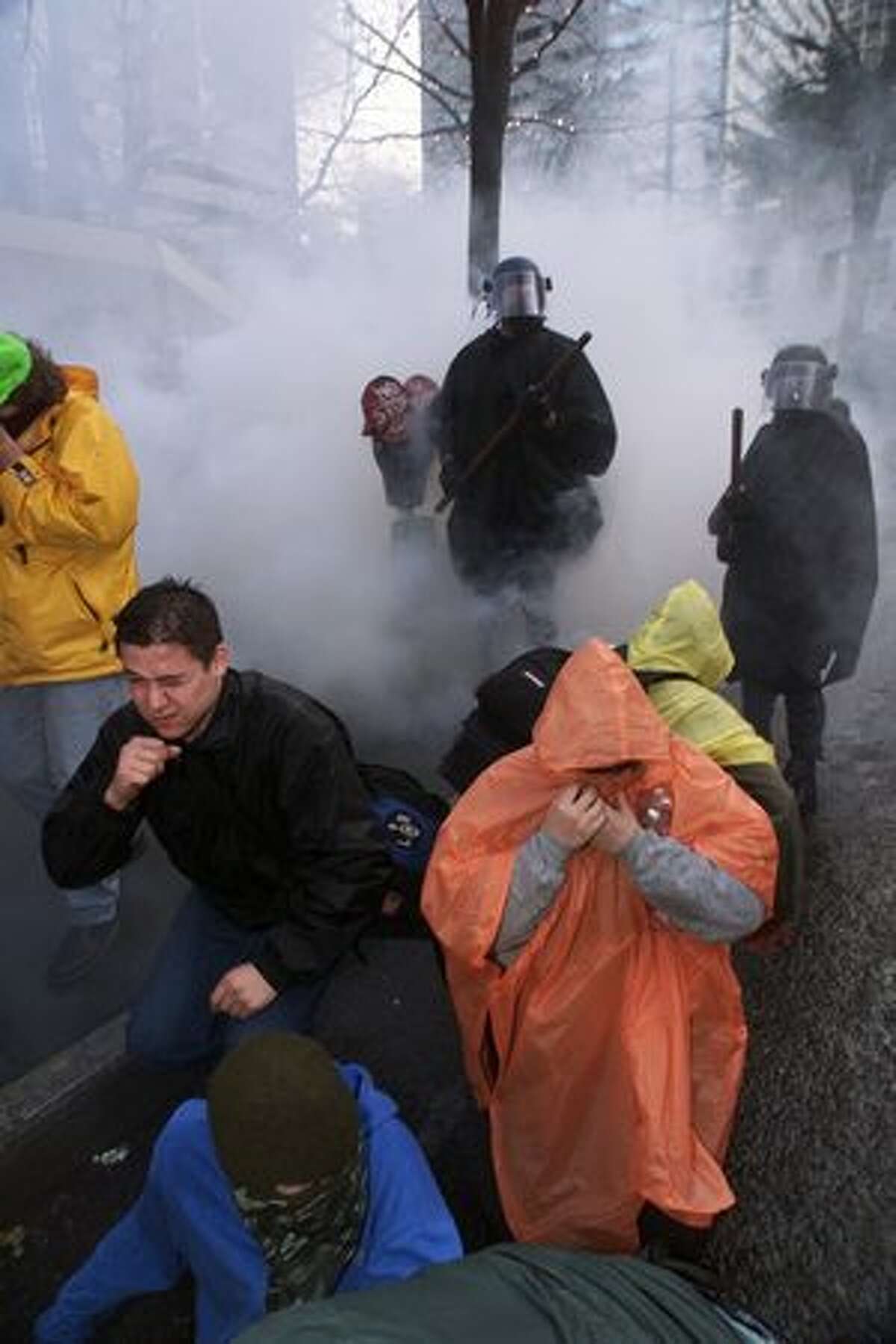 People react to a cloud of tear gas while protesting the WTO on Nov. 30, 1999.