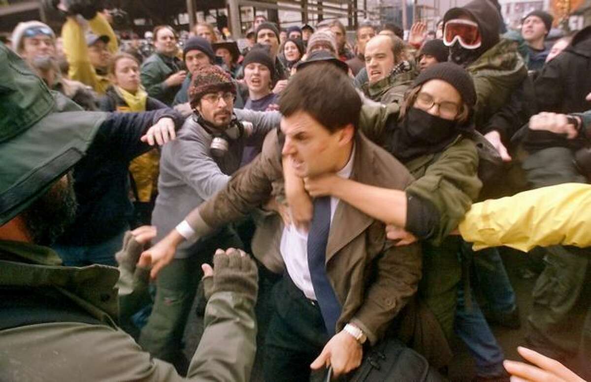 A WTO delegate is mauled by protestors at Seventh Avenue and Union as they try to prevent his access to the Washington State Convention & Trade Center on Nov. 30, 1999. (Photo by Mike Urban)