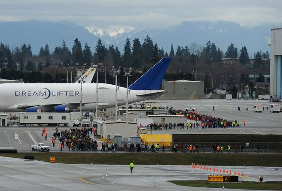 Hundreds of Boeing employees and representatives from companies that helped build the 787 gather as they walk to the viewing point to watch the airplane fly for the first time at Paine Field in Everett.