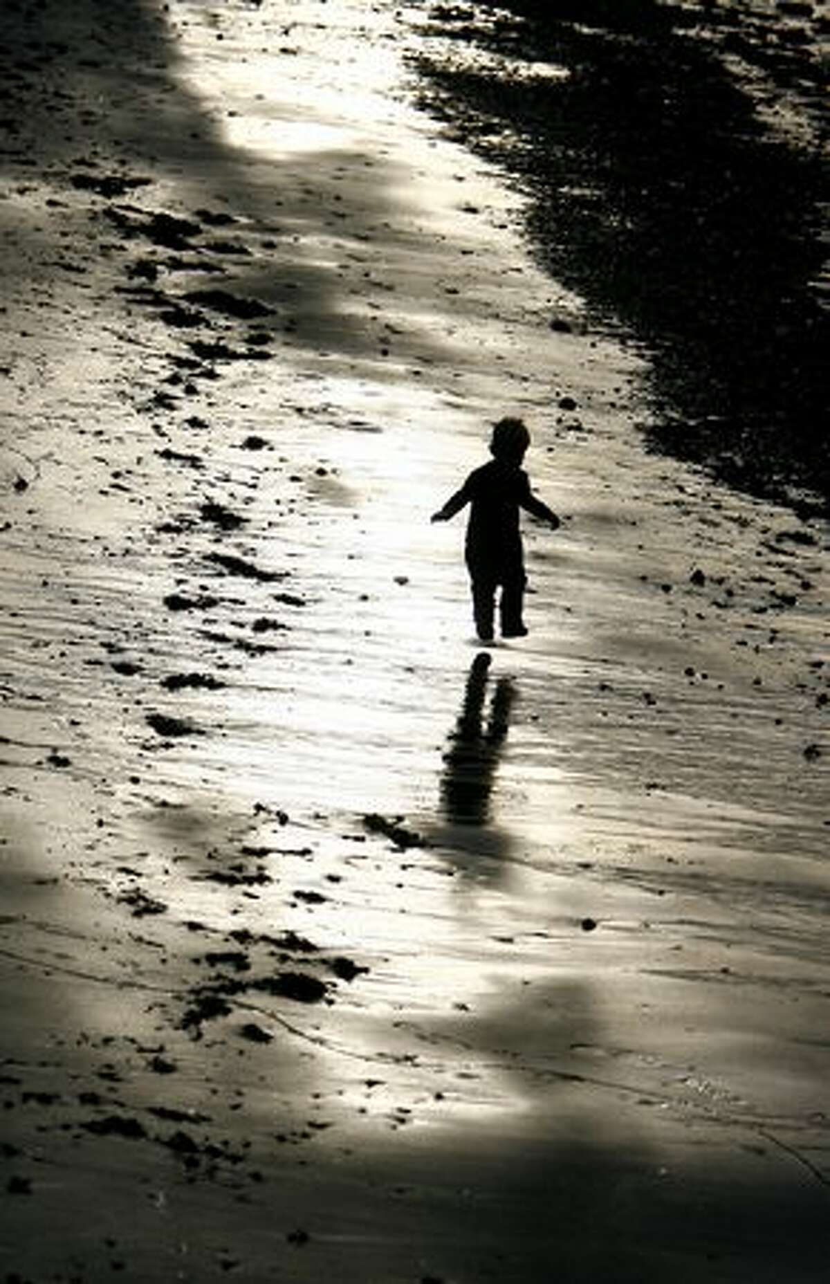 A young boy runs while playing on the beach during an outgoing tide at Alki on Feb. 4, 2009.