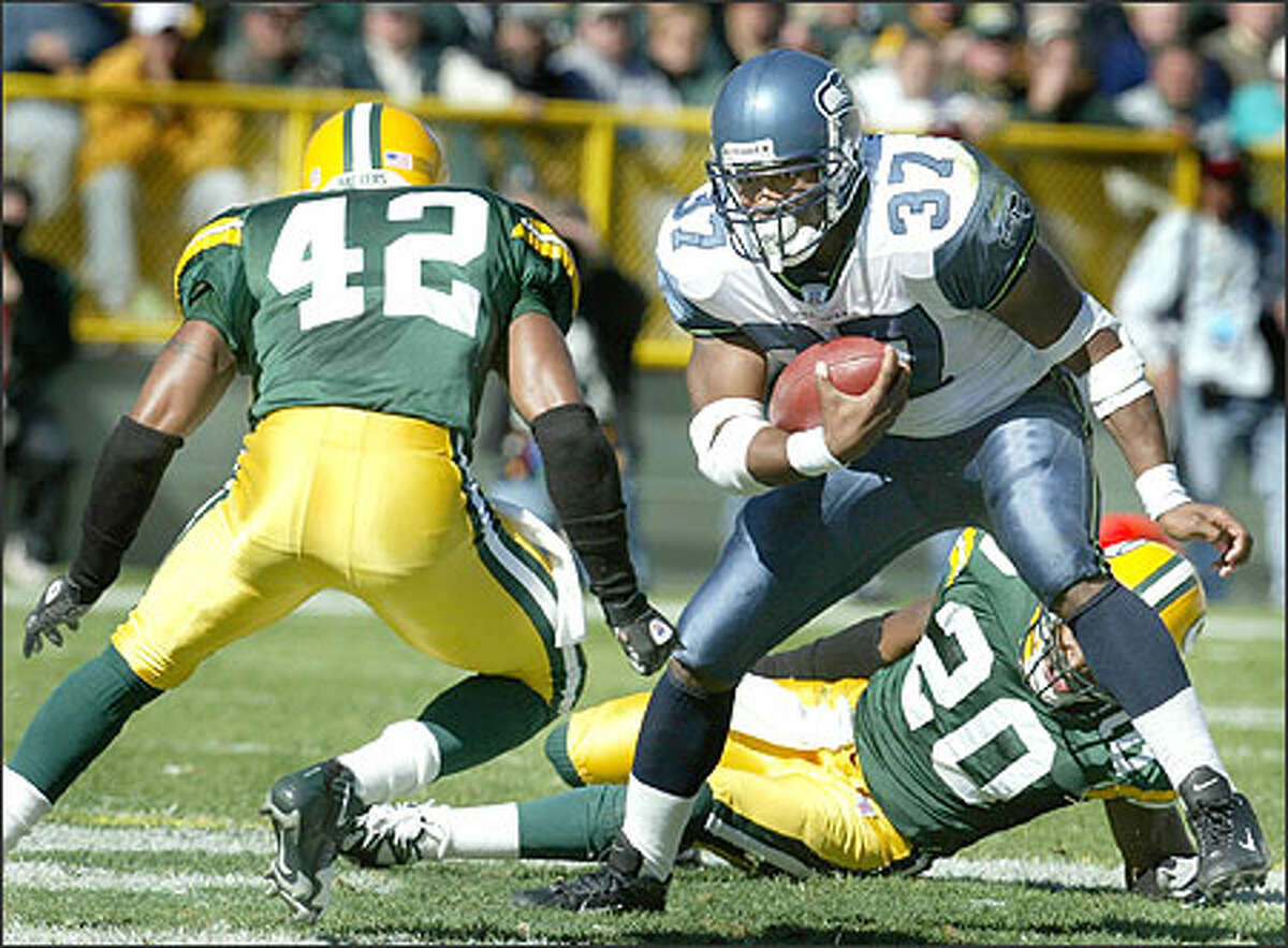 Seahawks running back Shawn Alexander tries to avoid Packer's Darren Sharper after having just run past Marques Anderson in the third quarter.