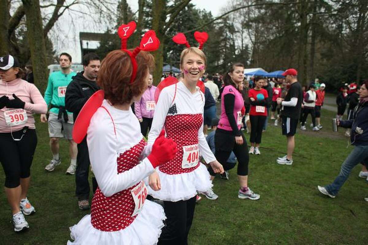 Holly Martin and Mo Gillis make their way to the starting line of the Love 'Em or Leave 'Em Valentine's Day Dash in Green Lake on Saturday morning. The 5K run and walk drew approximately 3,000 participants, according to organizers. (David Ryder/seattlepi.com)