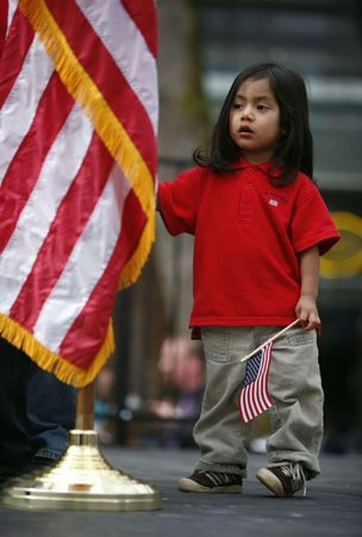 Ivan Hernandez, 2, stands near the podium as his brother Irais, 11, speaks during an immigration reform rally in Seattle's Occidental Park on Saturday April 10, 2010. The boys' dad was detained by immigration officials and may be sent back to his native Mexico. Speaker Pramila Jayapal, executive director of OneAmerica, said her organization is demanding that a bill be introduced in congress for immigration reform by May 1st.