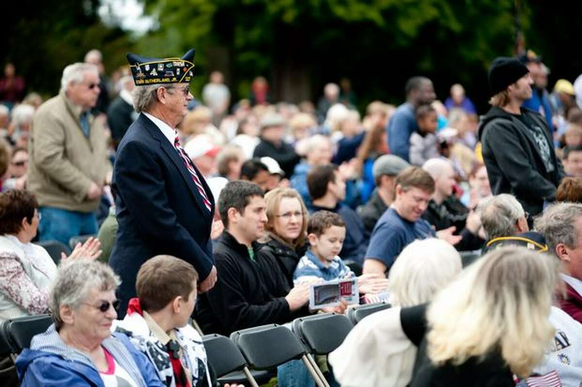 Veterans rise to applause as their song is played during a Memorial Day service in Seattle.