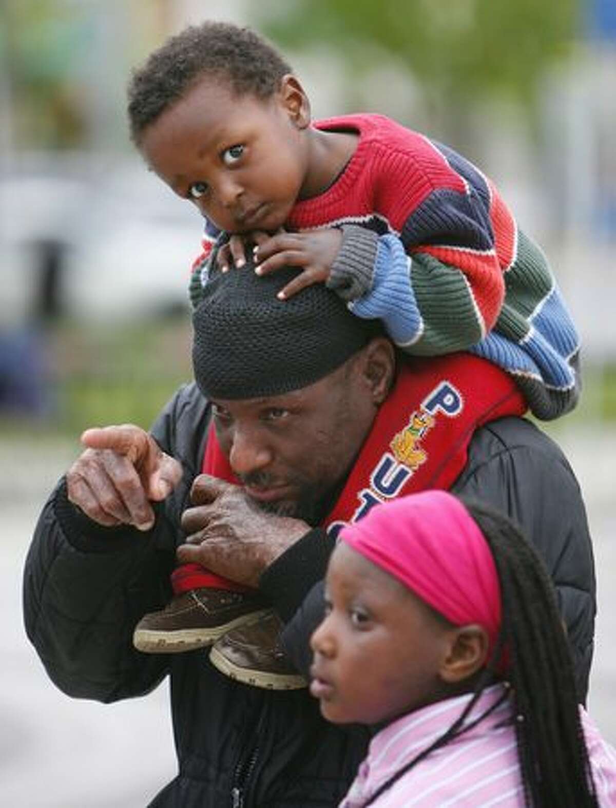 Khalfami Mwamba watches a performance with his son Oteko, 2, and daughter Ndalo, 8, during a Juneteenth community celebration hosted by the Atlantic Street Center at the Rainier Beach Community Center on Thursday June 17, 2010. Juneteenth is a holiday that commemorates African American freedom from slavery, while emphasizing education and achievement. This is the 10th year the Atlantic Street Center has hosted the celebration in Seattle.