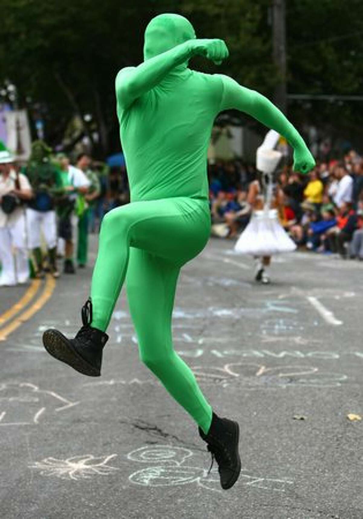 A green man runs across North 36th Street during the Fremont Solstice Parade on Saturday June 19, 2010 in Seattle.