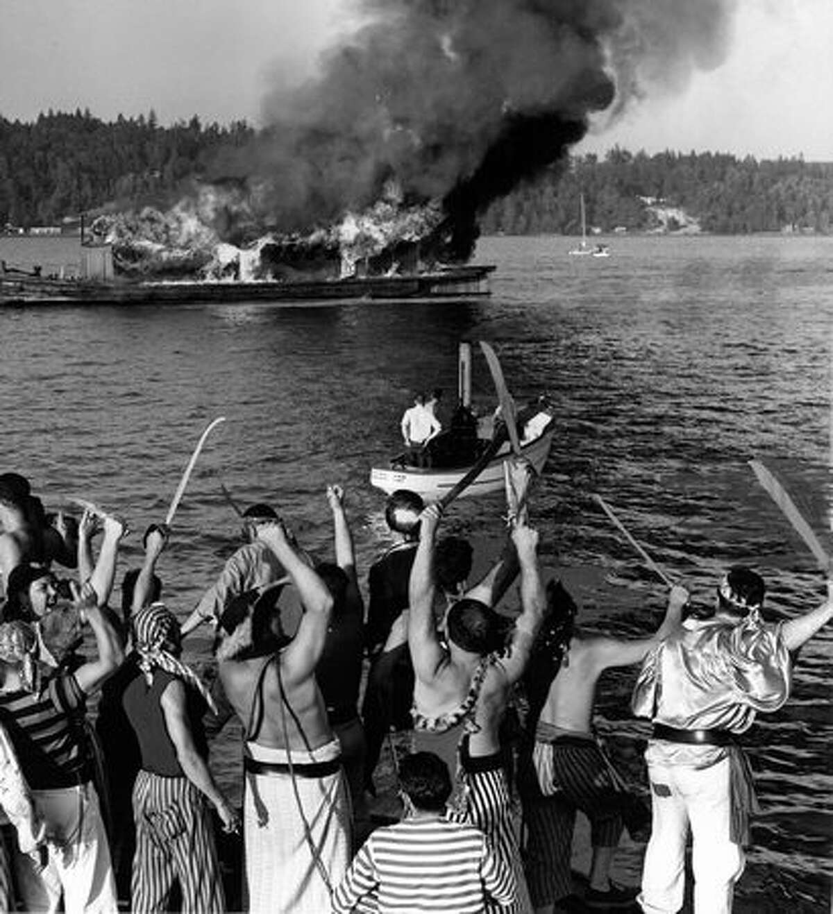 Seafair Pirates burn King Neptune's ship in Andrews Bay off Seward Park tp mark the end of Seafair 1956.