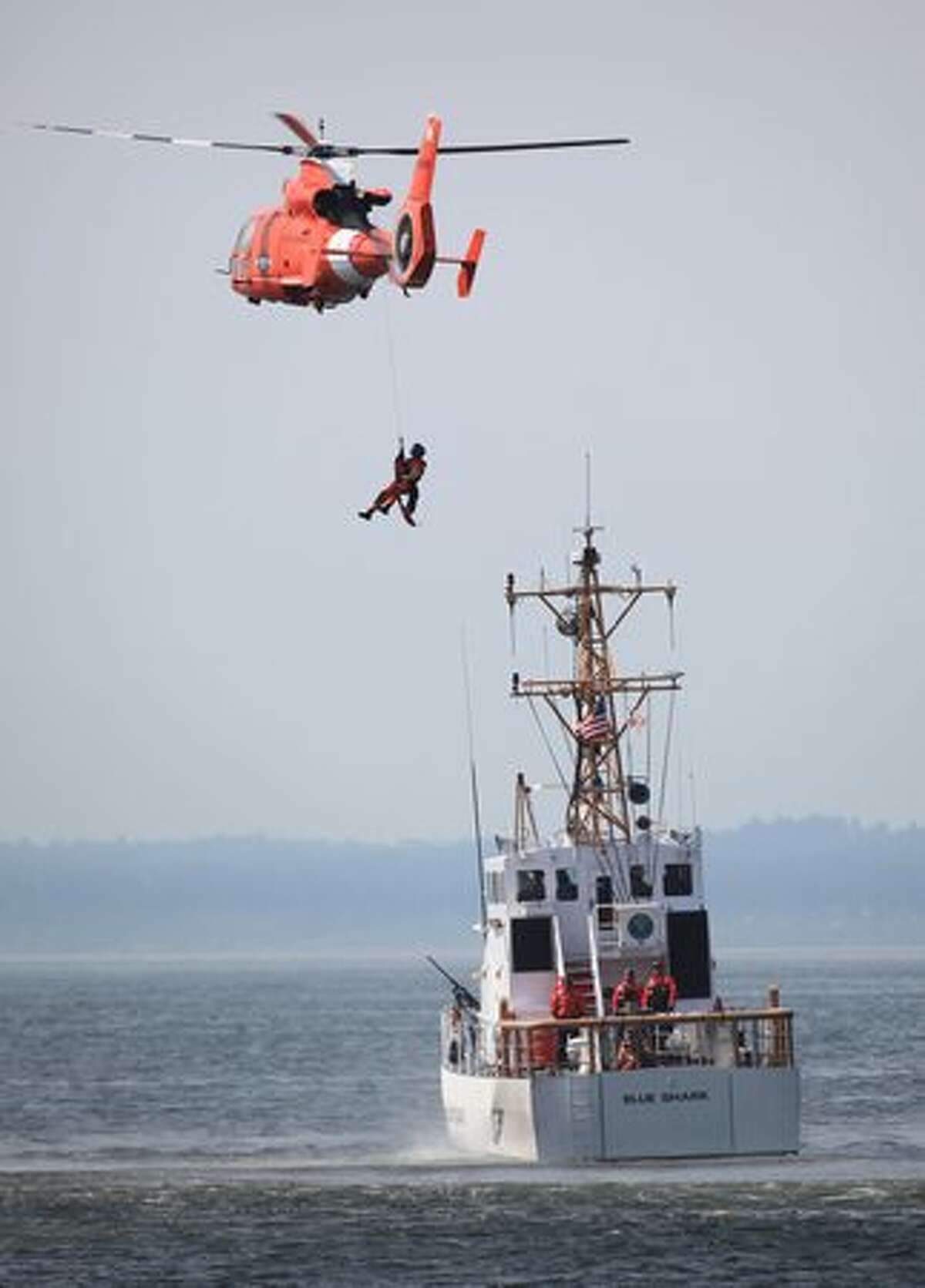A U.S. Coast Guardsmen performs an exercise during U.S. Navy Fleet Week's Parade of Ships in Elliott Bay along the Seattle waterfront on Wednesday August 4, 2010. The parade is part of Seattle's annual Seafair celebration.