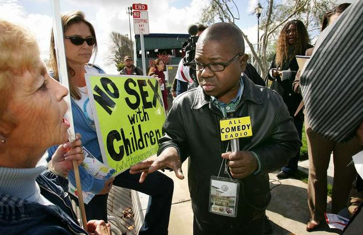 Demonstrators who suggest that pop icon Michael Jackson is guilty of child abuse confront actor Gary Coleman (C) as he works for a comedy radio show while Jackson is in court on the first day of opening statements for his child molestation trial on Feb. 28, 2005, in Santa Maria, Calif.