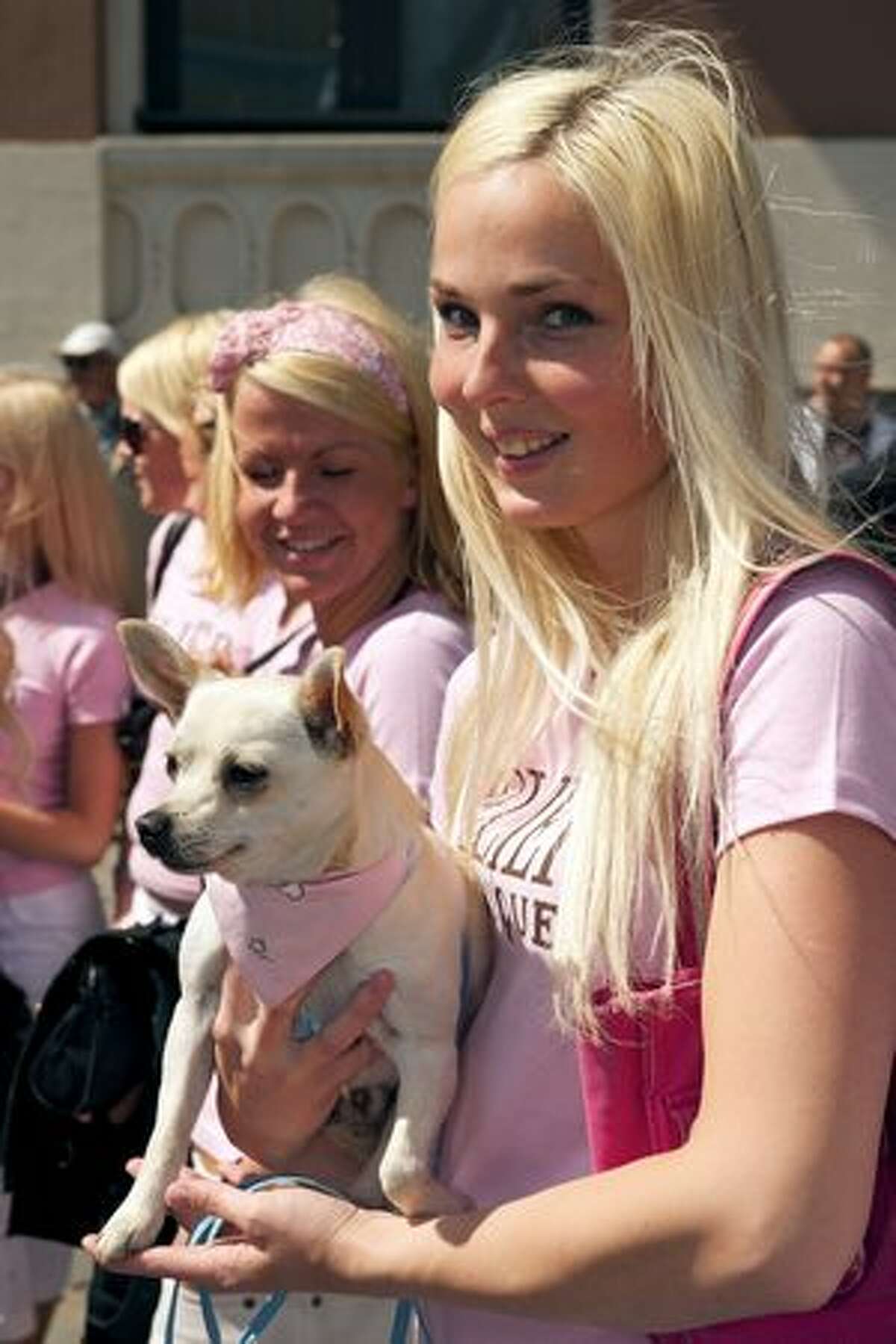 A Blond woman poses with her dog as they parade through the streets of Latvia's capital Riga during a Blond weekend.