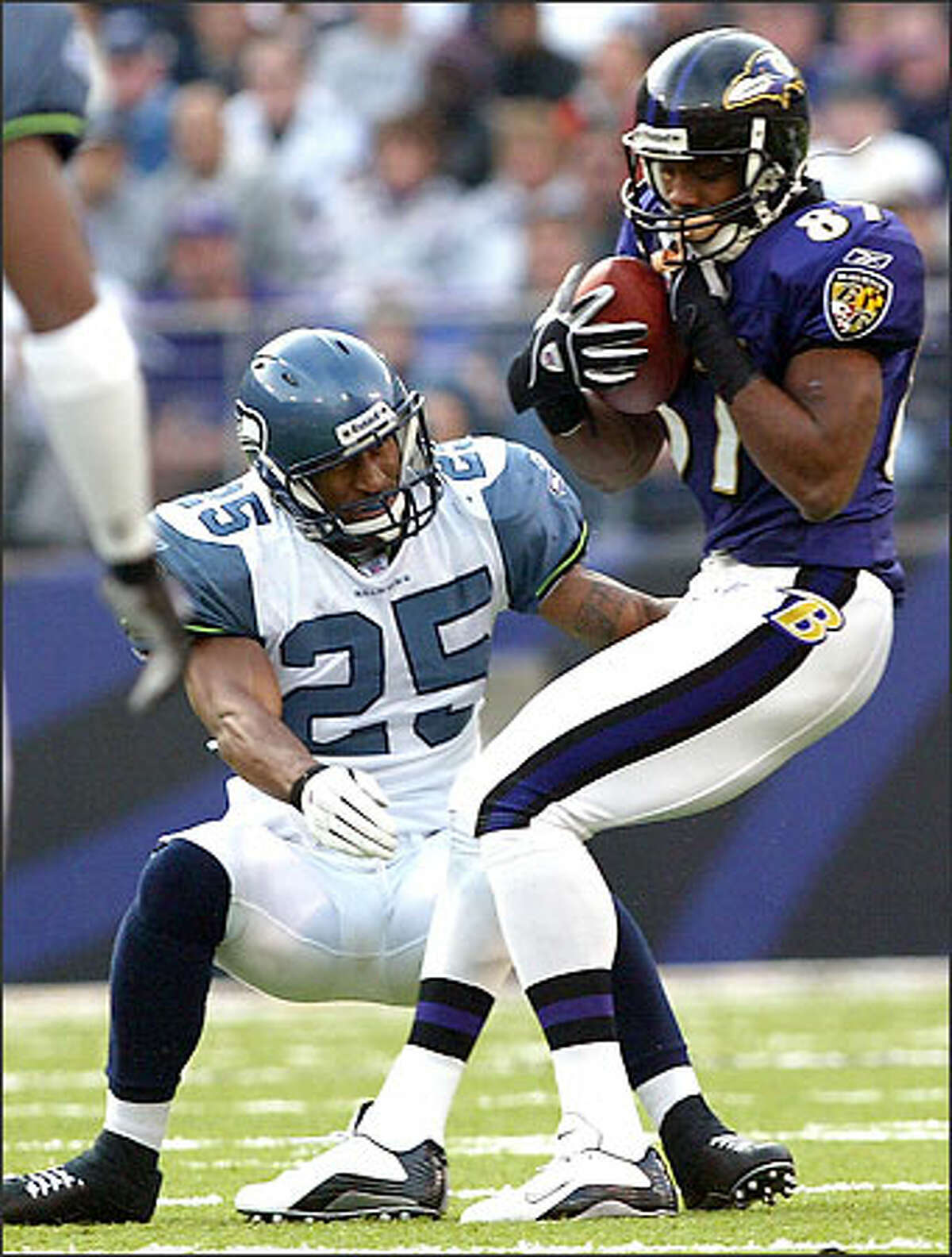 Ravens receiver Marcus Robinson breaks a tackle by Seahawk Reggie Tongue and runs for a 50-yard touchdown during the third quarter. Robinson had nine catches and no TDs in the Ravens' first 10 games; he caught seven and scored four in this outing.