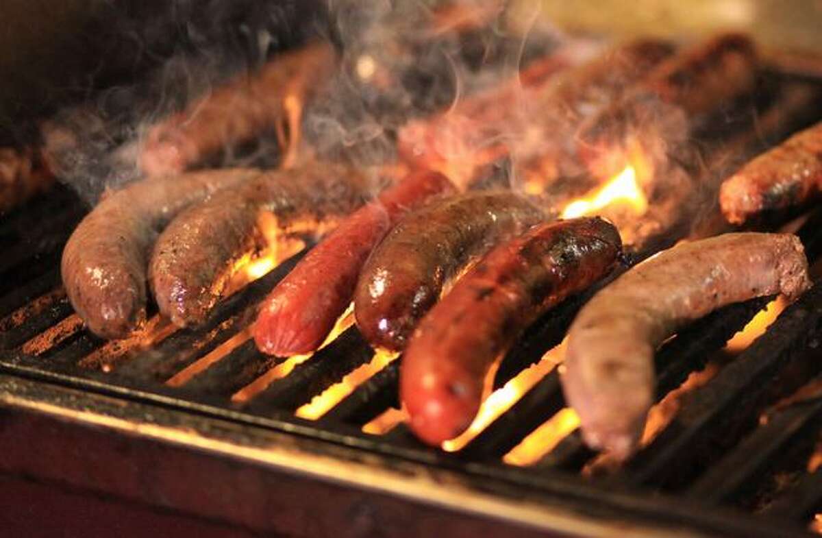Sausages from Al's Gourmet sizzle on a grill during the Mobile Chowdown.
