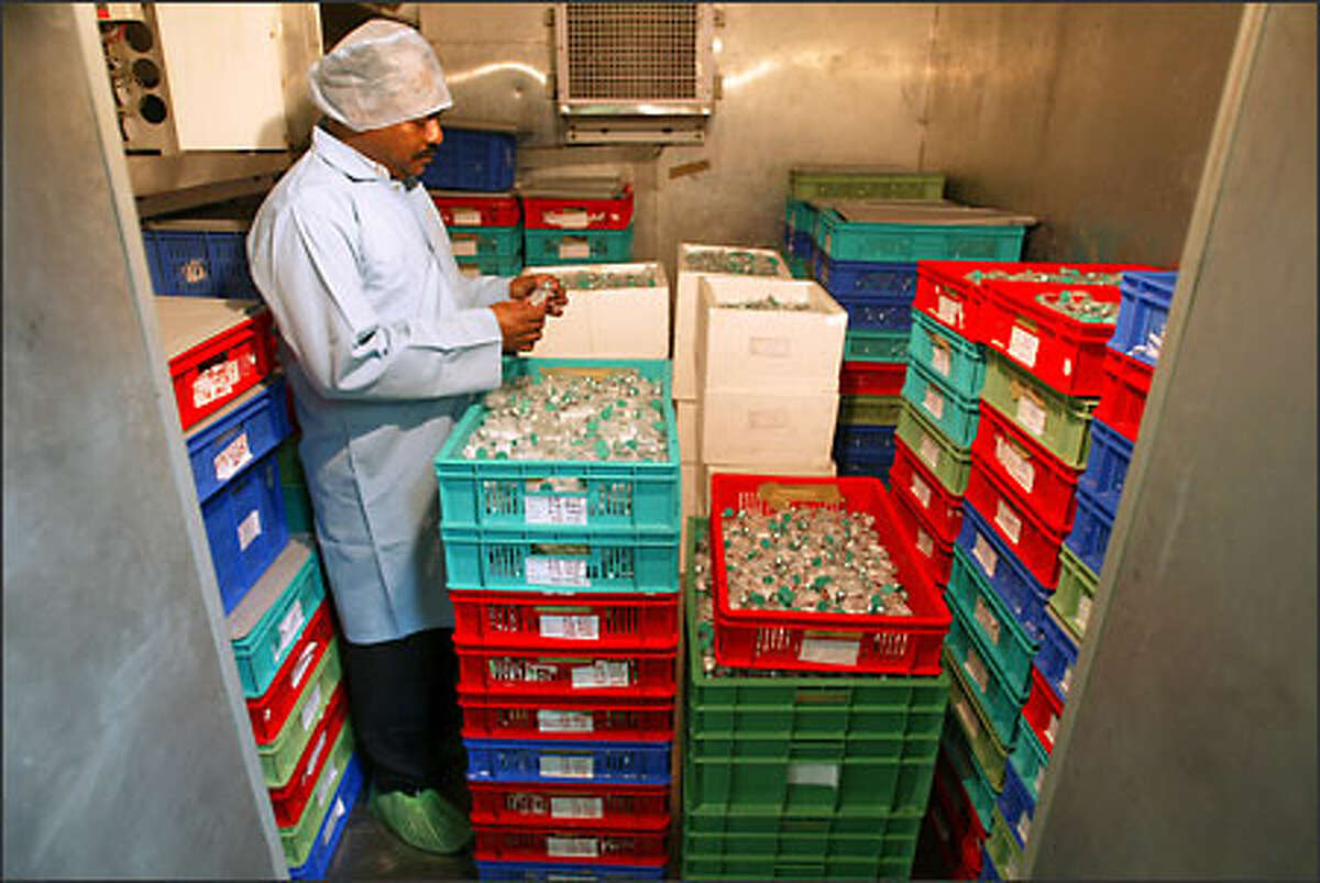 A technician in a biotechnology firm in Hyderabad, India, examines a stockpile of vaccines against hepatitis B, a virus that kills nearly a million people every year.