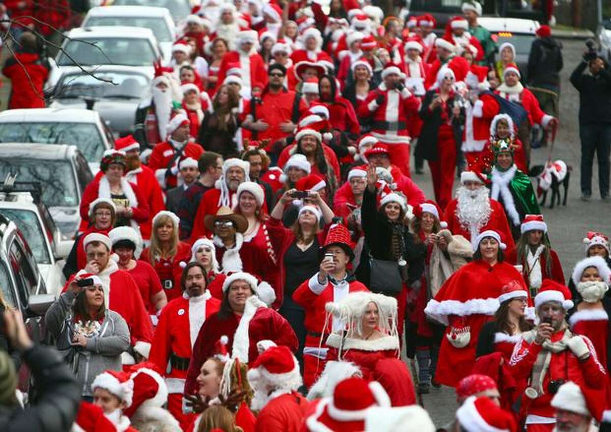 Hundreds of people dressed as jolly old elves march along North 36th Street toward Fremont's watering holes during SantaCon on Saturday, December 18, 2010. Hundreds of "Santa Clauses" walked the streets of Fremont, gathered in bars and consumed pitchers of Christmas cheer as part of SantaCon 2010.