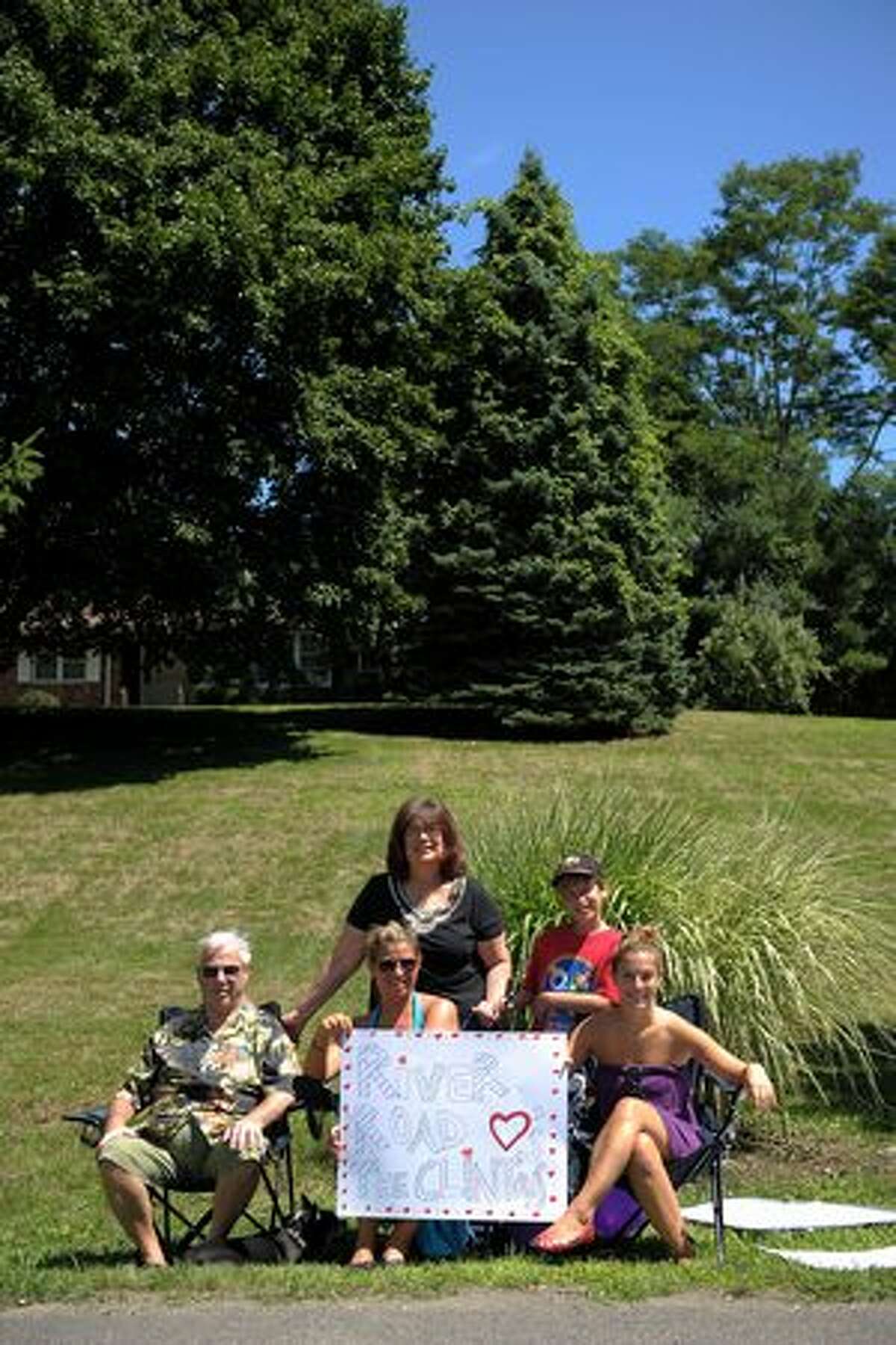 Rhinebeck residents (front row L-R) Norman Gastman, Rachael Scorca, Harleigh Gastman, (back row L-R) Amy Scorca and Uri Rooselaar hold up a sign showing their support as the town prepares for the wedding of Chelsea Clinton and Marc Mezvinsky on July 31, 2010 in Rhinebeck, New York.