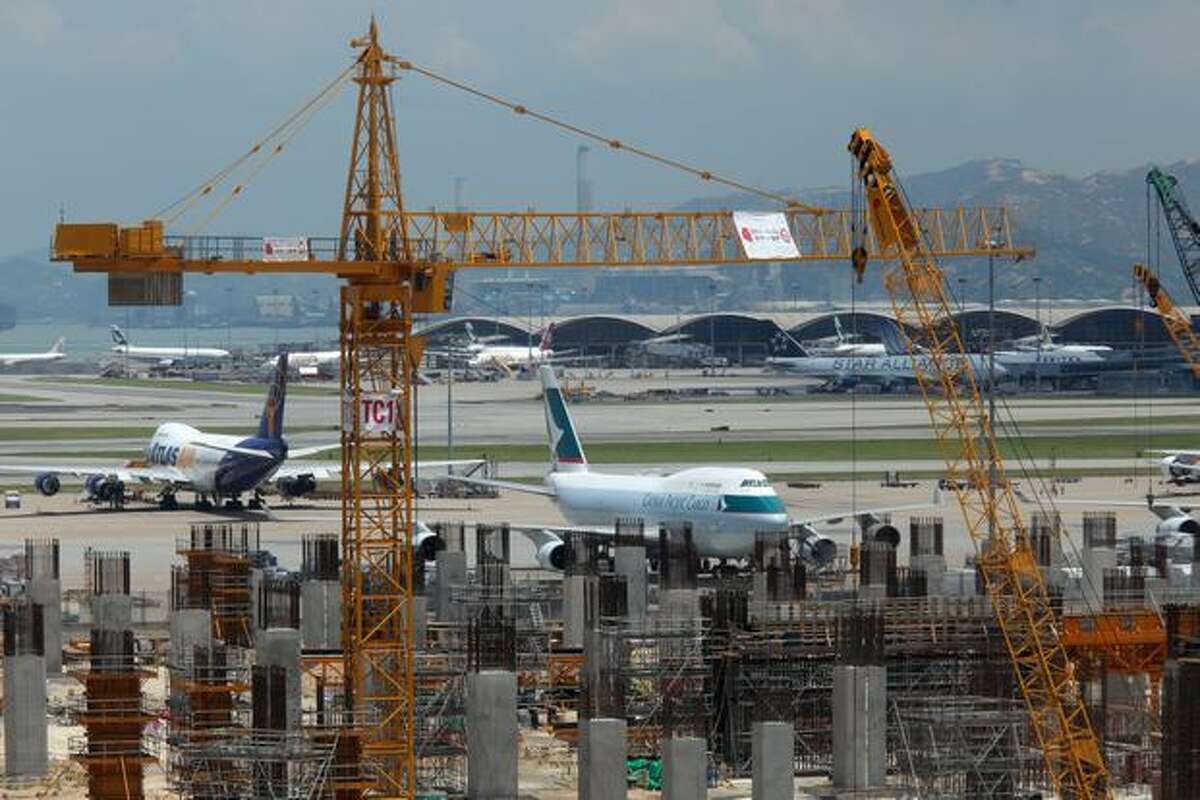 A Cathay Pacific cargo aircraft sits parked behind the site of the company's new cargo terminal at Hong Kong International Airport