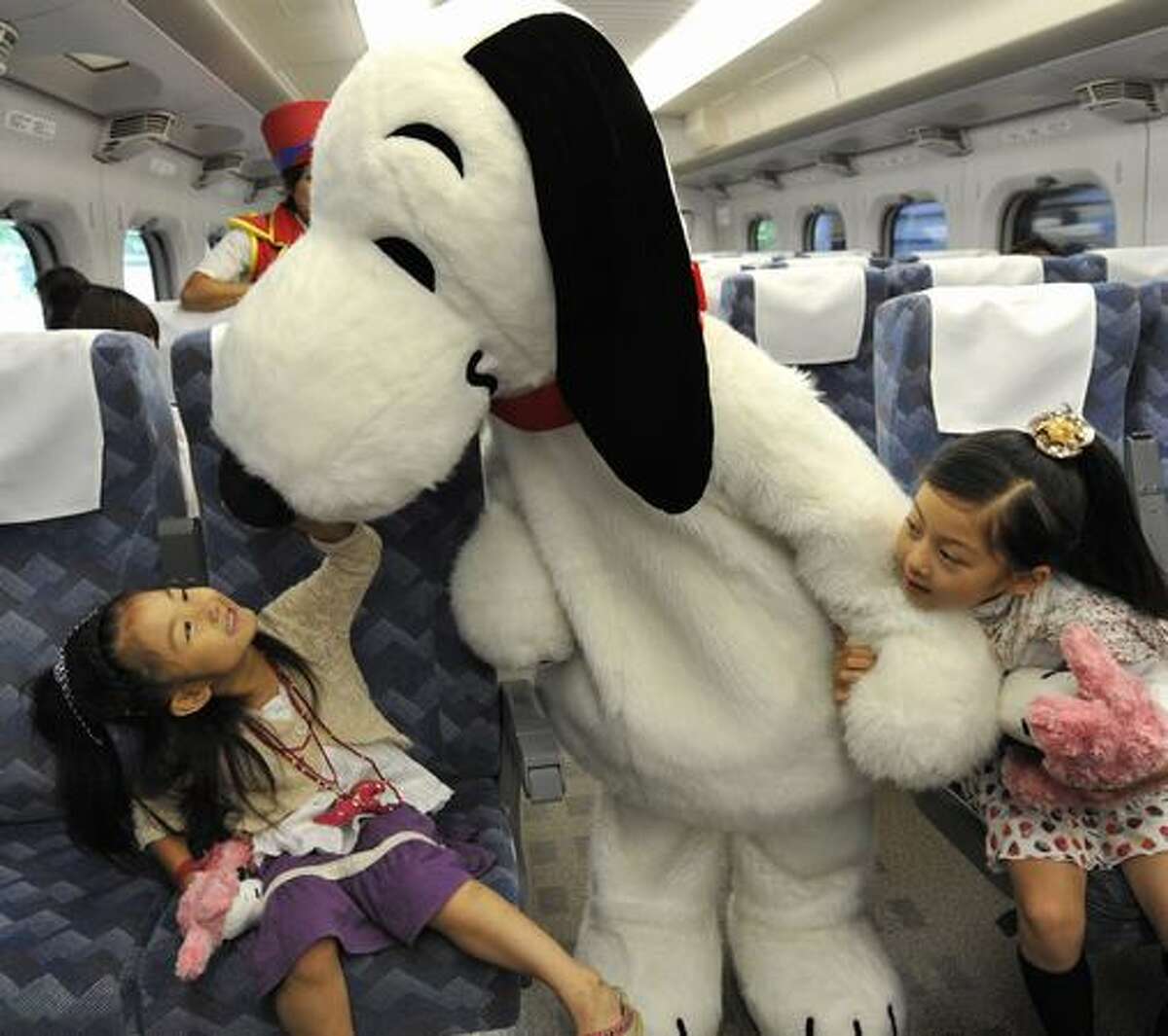 Cartoon character Snoopy greets children in the Shinkansen bullet train heading to Osaka from Tokyo for the promotion of Osaka based Hollywood theme park Universal Studios Japan on July 26, 2009.