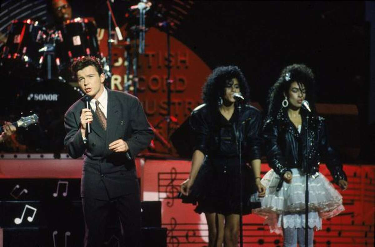 Pop star Rick Astley ("Never Gonna Give You Up") performs with two backing singers, 1986.