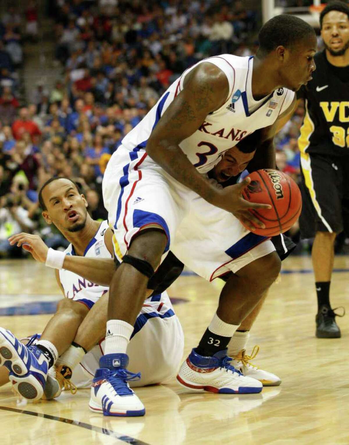 Kansas guard Josh Selby (32) gets tangled up with Virginia Commonwealth guard Joey Rodriguez (12) and Kansas guard Travis Releford (24) during the first half of the NCAA Southwest Regional final in San Antonio, Texas on Sunday, March 27, 2011. (Jerry Lara/glara@express-news.net)
