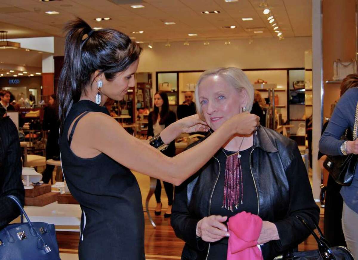 Padma Lakshmi helps Darlene Crenz try on one of her newly designed necklaces at Mitchell's of Westport.