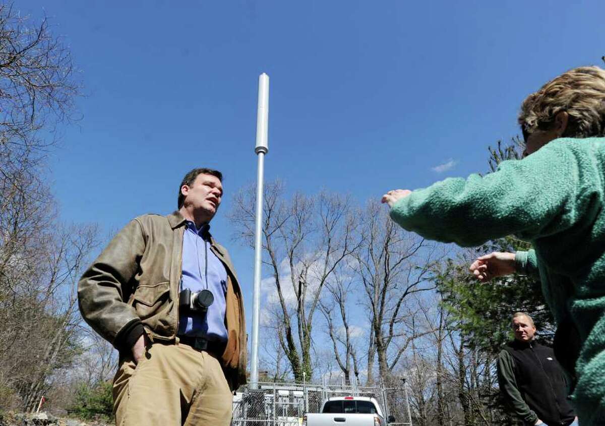 John Bowman, left, who lives at 56 Ritch Ave., Byram, during a tour of a Verizon Wireless proposed 77-foot cell tower, voices his displeasure at plans to install a taller cell tower so close to his property. The tower would replace the 70-foot AT&T flag pole cell tower, pictured, at 36 Ritch Ave., Byram, Tuesday afternoon, March 29, 2011. The new tower would be desgined to look like a pine tree.