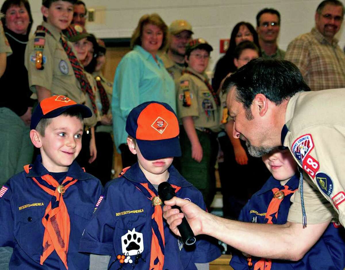 SPECTRUM/Scoutmaster Craig Impellizzeri does his best to encourage Cub Scout Jack Ellis, 6, to offer a growl during Pack 58's annual Blue and Gold banquet March 19 at Sarah Noble Intermediate School in New Milford. Looking on in amusement are Matthew Rivard, 7, left, and Nathan Perreault.