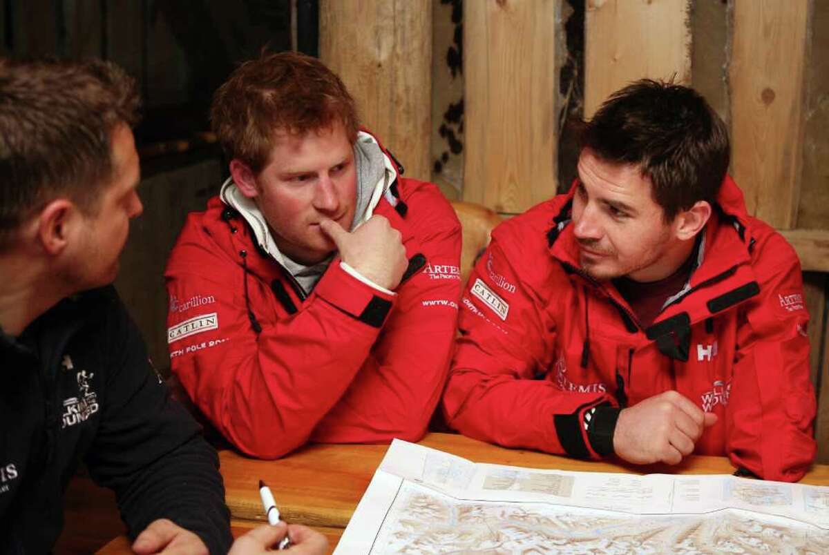 SPITSBERGEN, NORWAY - MARCH 29: Prince Harry looks at some maps with team leader Inge Solheim (left) and Jaco Van Gass (right) as he joins the Walking with the Wounded team on the island of Spitsbergen, which is situated between the Norwegian mainland and the North Pole, for their last days of packing before setting off to walk to the North Pole on March 29, 2011 in Spitsbergen, Norway. (Photo by David Cheskin/WPA Pool/Getty Images) *** Local Caption *** Jaco Van Gass;Inge Solheim;Prince Harry