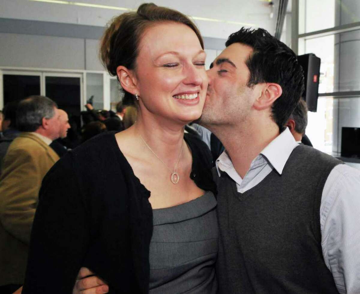 One of seven new lottery millionaires Gabrielle Mahar, left, of Colonie gets a kiss from Boyfriend Scott Conklin of Albany after a news conference at the New York Lottery offices in Schenectady Thursday morning March 31, 2011. The seven winners of the $319 million Mega Millions, are state workers with the NYS Homes and Community Renewal and bought the winning ticket at Coulson's, around the corner from their downtown Albany office. (John Carl D'Annibale / Times Union)