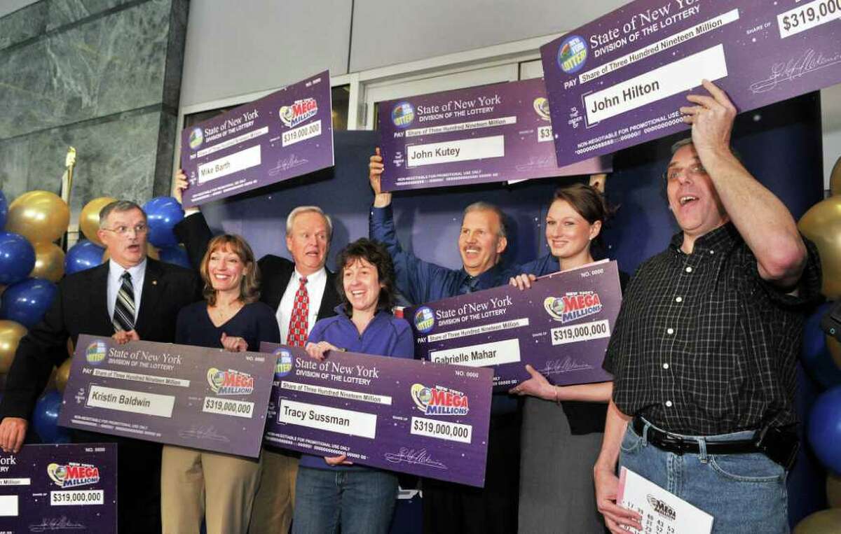 Newest lottery millionaires, from left, Leon Peck of Johnstown, Kristin Baldwin of Clifton Park, Mike Barth of Bethlehem, Tracy Sussman of Colonie, John Kutey of Green Island, Gabrielle Mahar of Colonie and John Hilton of North Greenbush during a news conference at the New York Lottery offices in Schenectady Thursday morning March 31, 2011. The seven winners of the $319 million Mega Millions, are state workers with the NYS Homes and Community Renewal and bought the winning ticket at Coulson's, around the corner from their downtown Albany office. (John Carl D'Annibale / Times Union)