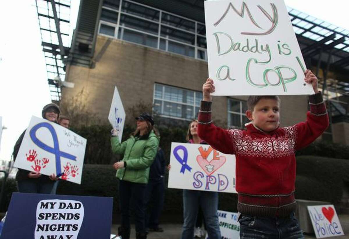 Jace, 7, holds a sign supporting his dad, a Seattle police officer, during the rally.