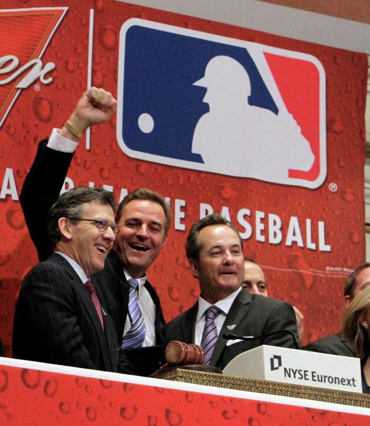 Tim Brosnan, left, with Major League Baseball, former major league pitcher Al Leiter, center, and Mark Wright, with Budweiser, ring the opening bell of the New York Stock Exchange in observance of baseball's opening day, Thursday, March 31, 2011.
