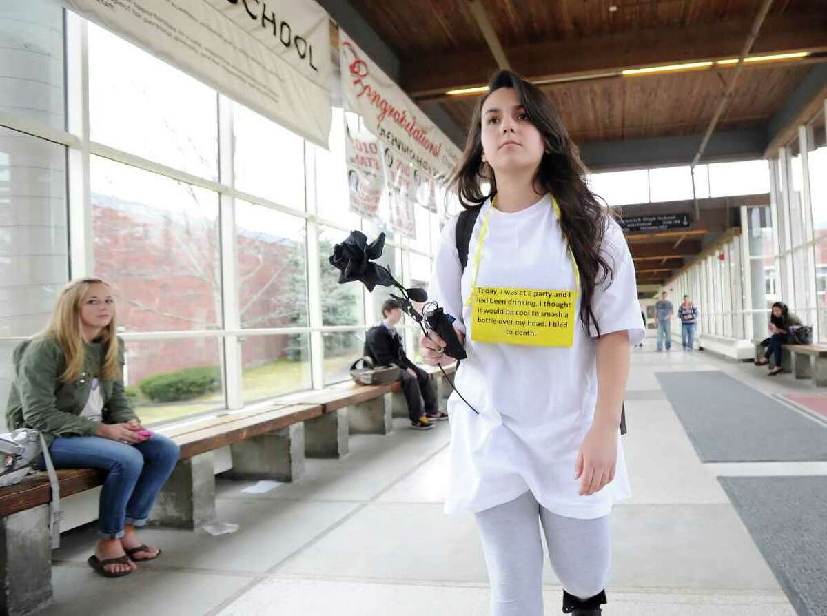 Greenwich High School junior Rebecca Pereira, 16, carries a black rose while wearing a sign around her neck detailing how she "died" as a victim of an alcohol-related tragedgy during “Grim Reaper Day” at Greenwich High School, Thursday afternoon, March 31, 2011. The Greenwich High School Outreach Club hosted the event to educate students about the possible deadly effects of underage drinking.