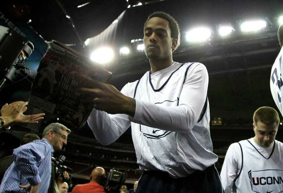 Connecticut forward Jamal Coombs-McDaniel, left, signs an autograph as the Huskies take the court before UConn's practice before the Final Four at Reliant Stadium Friday, April 1, 2011, in Houston. ( Brett Coomer / Houston Chronicle )