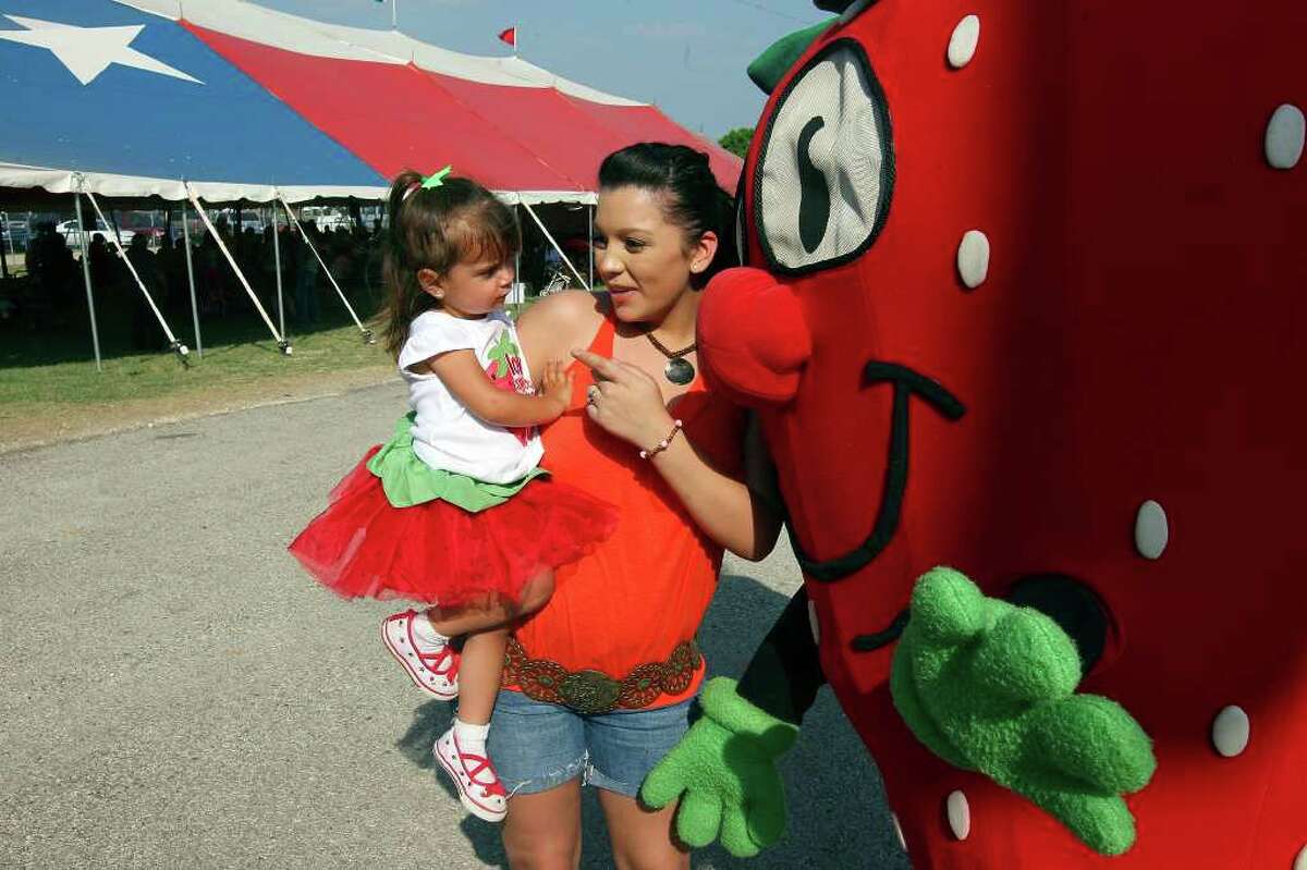 FOR METRO - Michaela Stimpson, 2, (left) and her cousin Ashlee Messick talk with Freckles, the official mascot, Saturday April 2, 2011 during the 64th Annual Poteet Strawberry Festival in Poteet, Tx. PHOTO BY EDWARD A. ORNELAS/eaornelas@express-news.net)