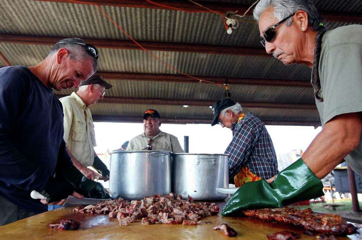 FOR METRO - John Earnest (left) and Daniel De La O (right) and others cut fajitas for the St. Matthew's Guadalupe Society booth Saturday April 2, 2011 during the 64th Annual Poteet Strawberry Festival in Poteet, Tx. PHOTO BY EDWARD A. ORNELAS/eaornelas@express-news.net)
