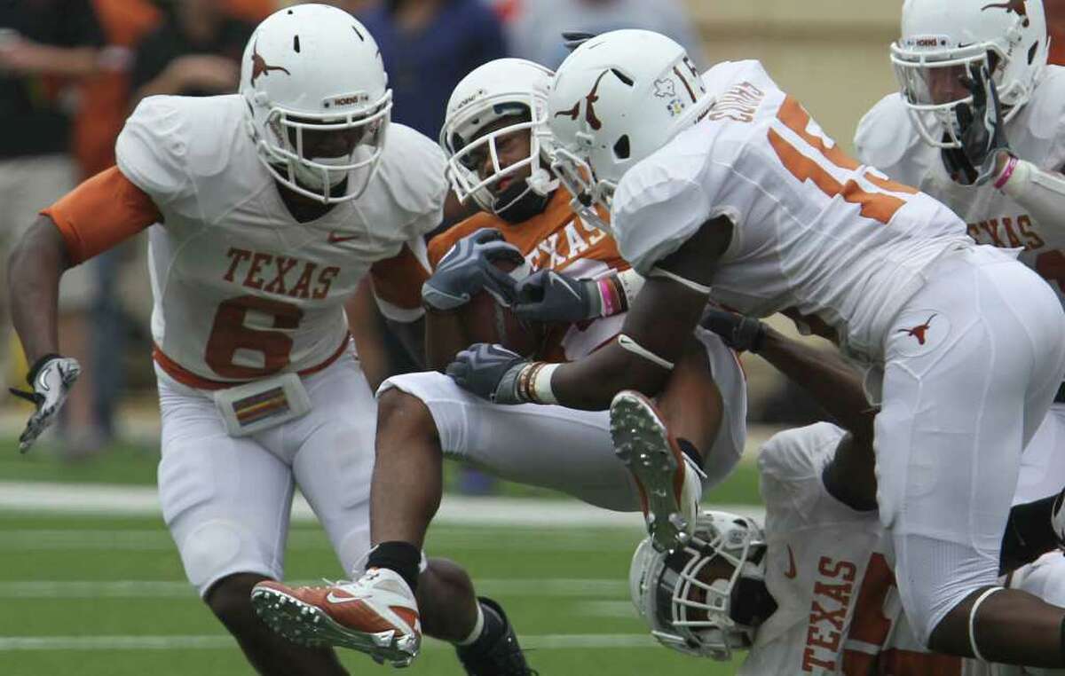 Wide receiver DeSean Hales (center) is stopped by Demarco Cobbs (right) with Christian Scott (left) during first half action at Darrell K. Royal-Texas Memorial Stadium in Austin during the annual University of Texas Spring Orange and White scrimmage game Sunday April 3, 2011. JOHN DAVENPORT/jdavenport@express-news.net