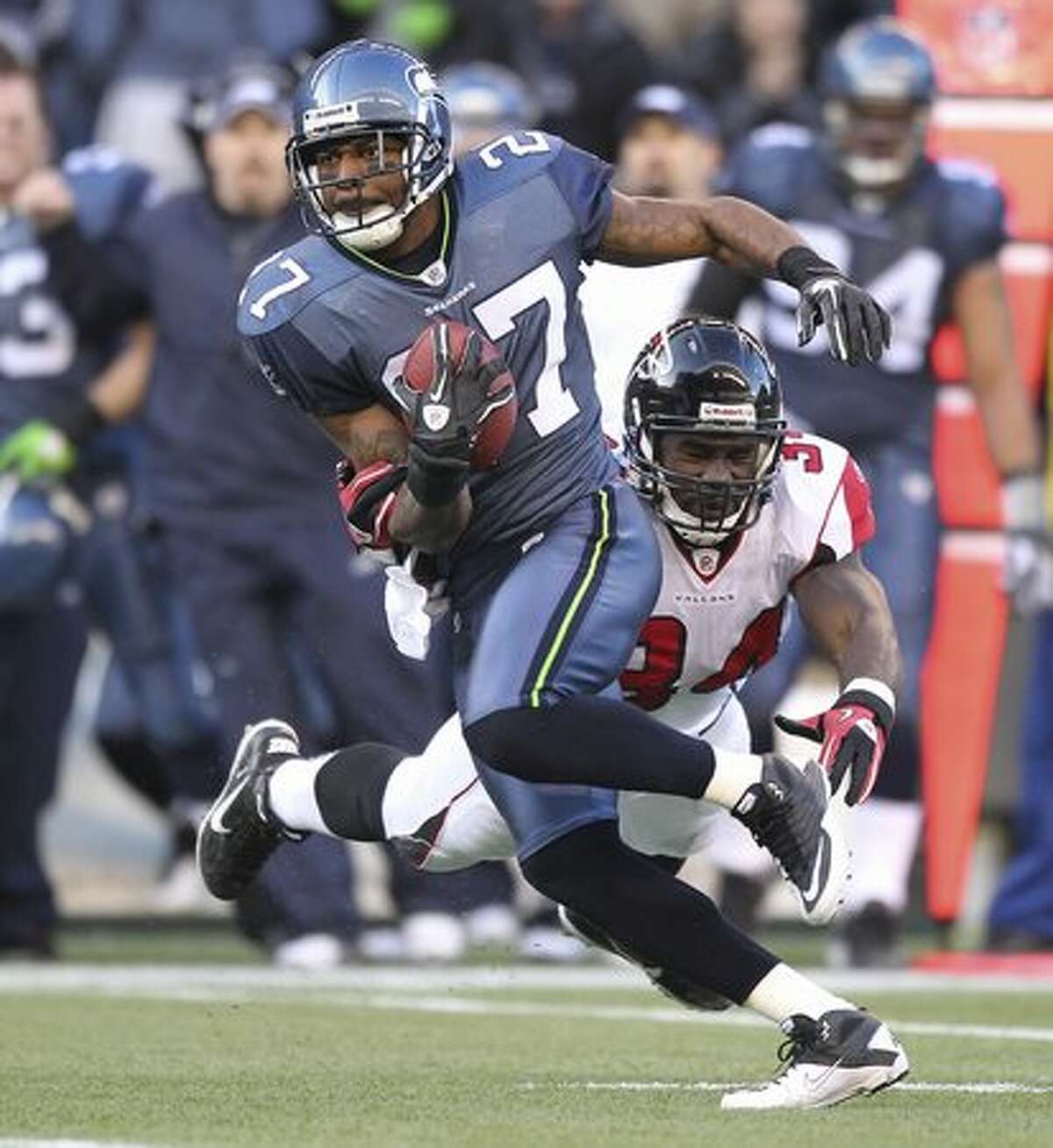Jordan Babineaux #27 of the Seattle Seahawks returns an interception against Ovie Mughelli #34 of the Atlanta Falcons.