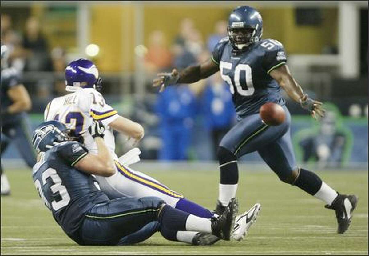 Seattle Seahawks' Craig Terrill tackles Minnesota Vikings Shaun Hill as he intentionally grounds the ball during fourth quarter action. The ball bounced off of Seahawks' Cleveland Pinkney (50).