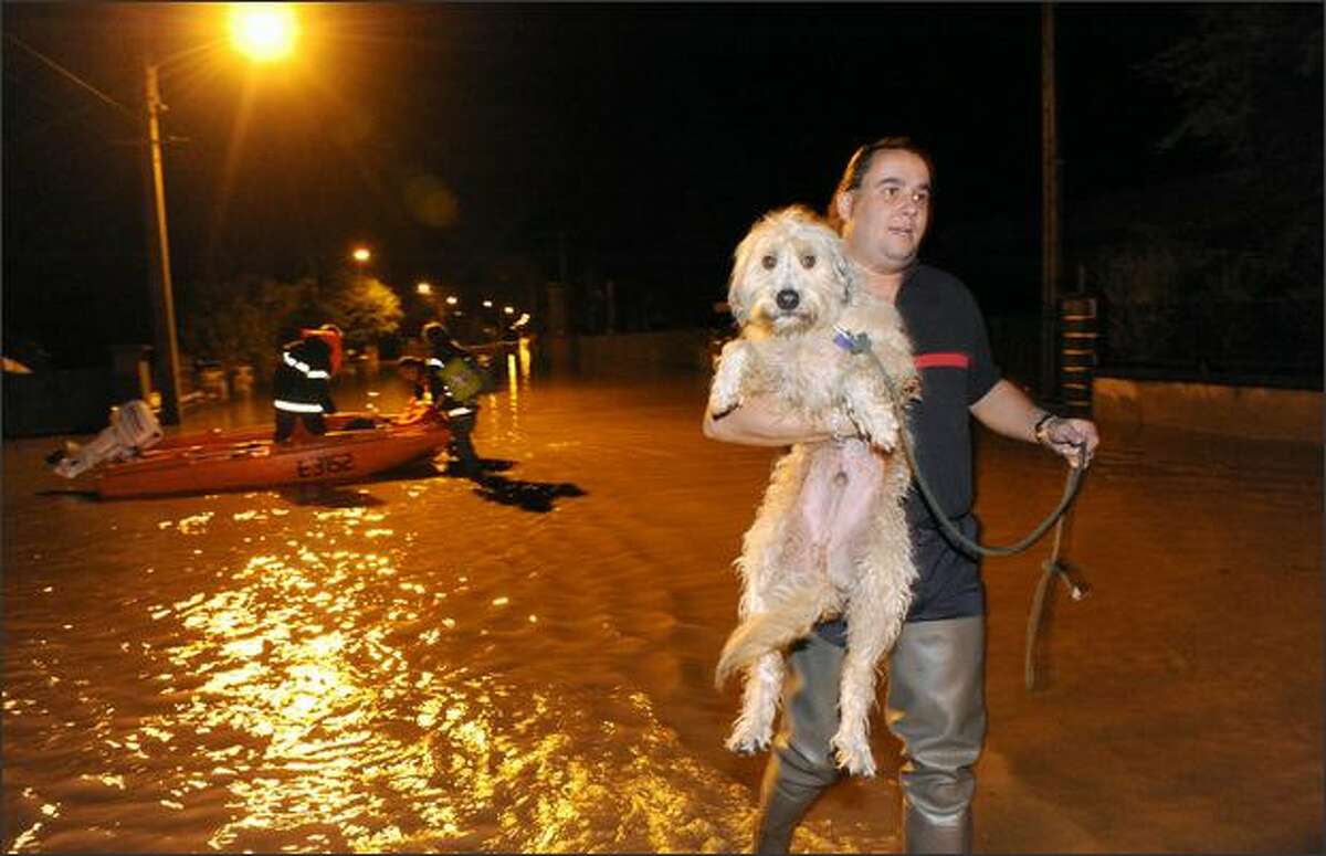 A fireman holds a dog during the evacuation of inhabitants in a flooded area of Brassac-les-Mines, central France, after the Allier river bursted its banks following torrential rains.