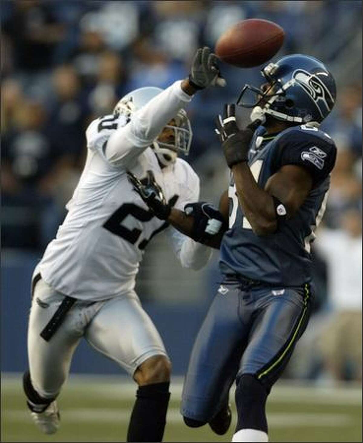 The Seahawks' Nate Burleson (right) has the ball knocked away by Oakland's Nnamdi Asomugha in the first quarter.