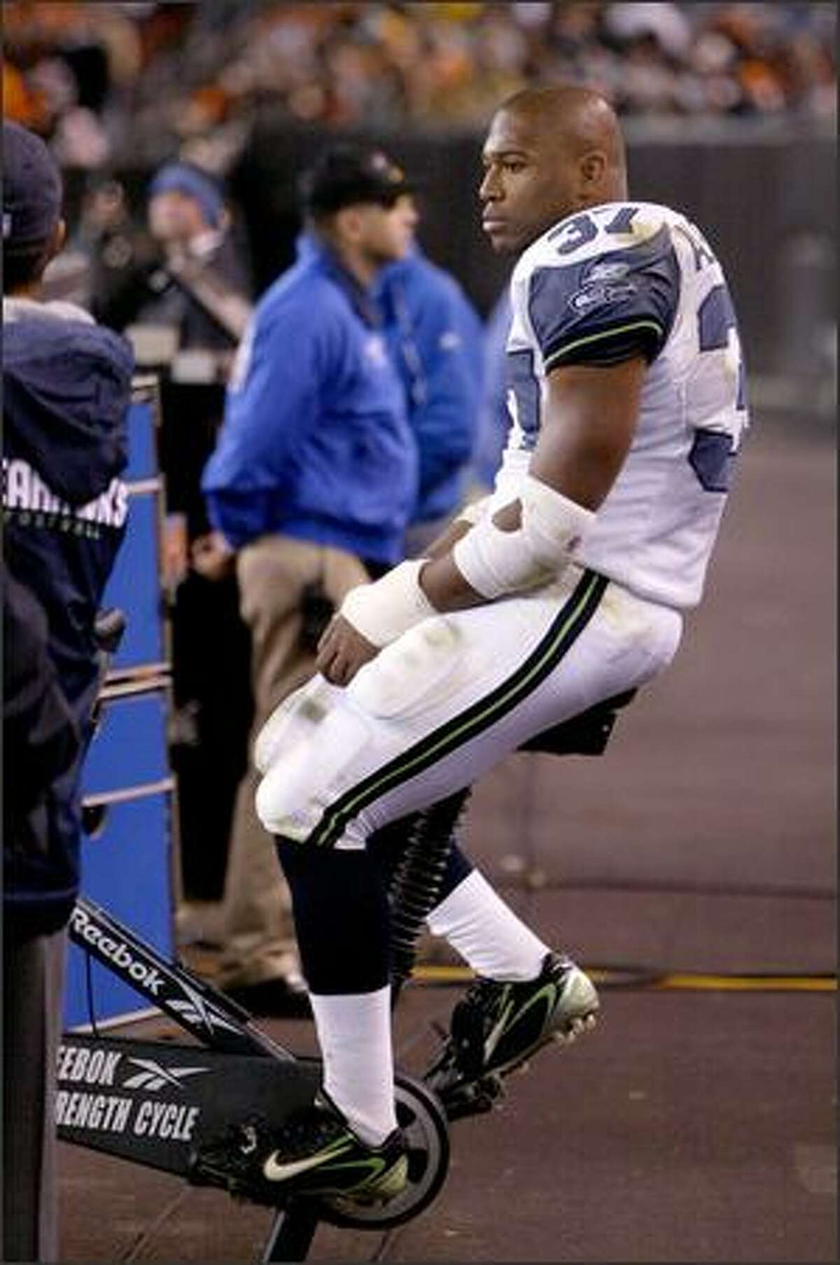 Shaun Alexander watches fourth quarter action from a stationary bike after being injured earlier in the game.