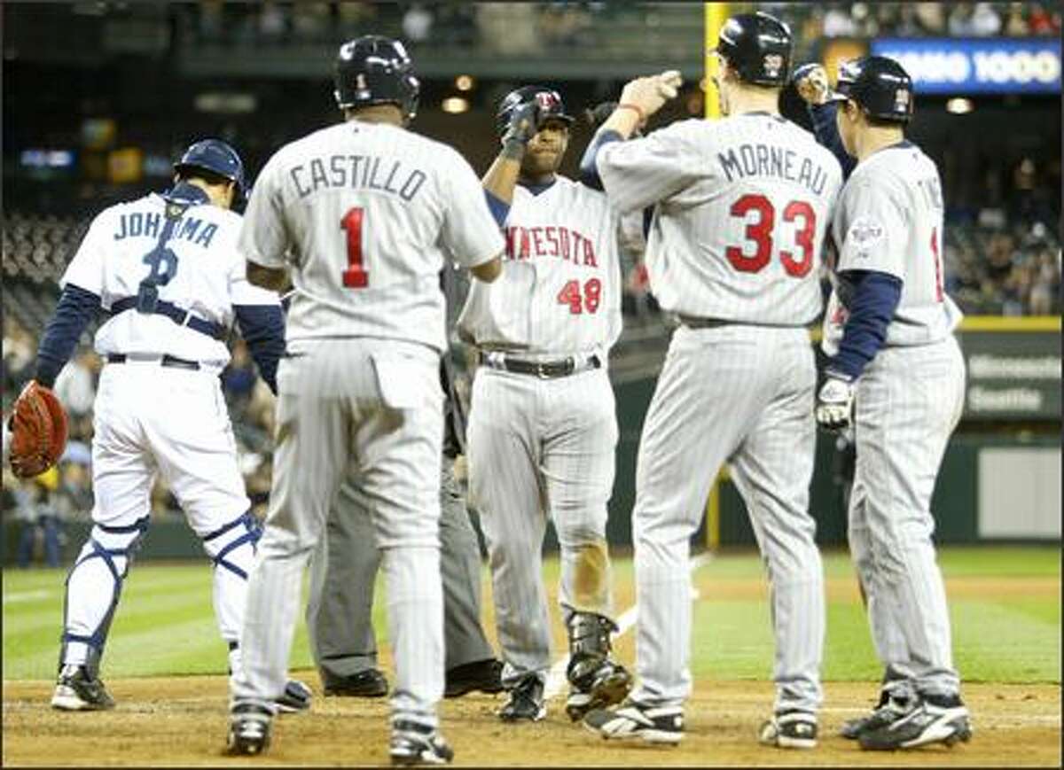 Minnesota Twins players gather at home plate after Torii Hunter hit a grand slam driving in Luis Castillo, Justin Morneau (33) and Jason Tyner (12) on Tuesday at Safeco Field during the fifth inning in Seattle.