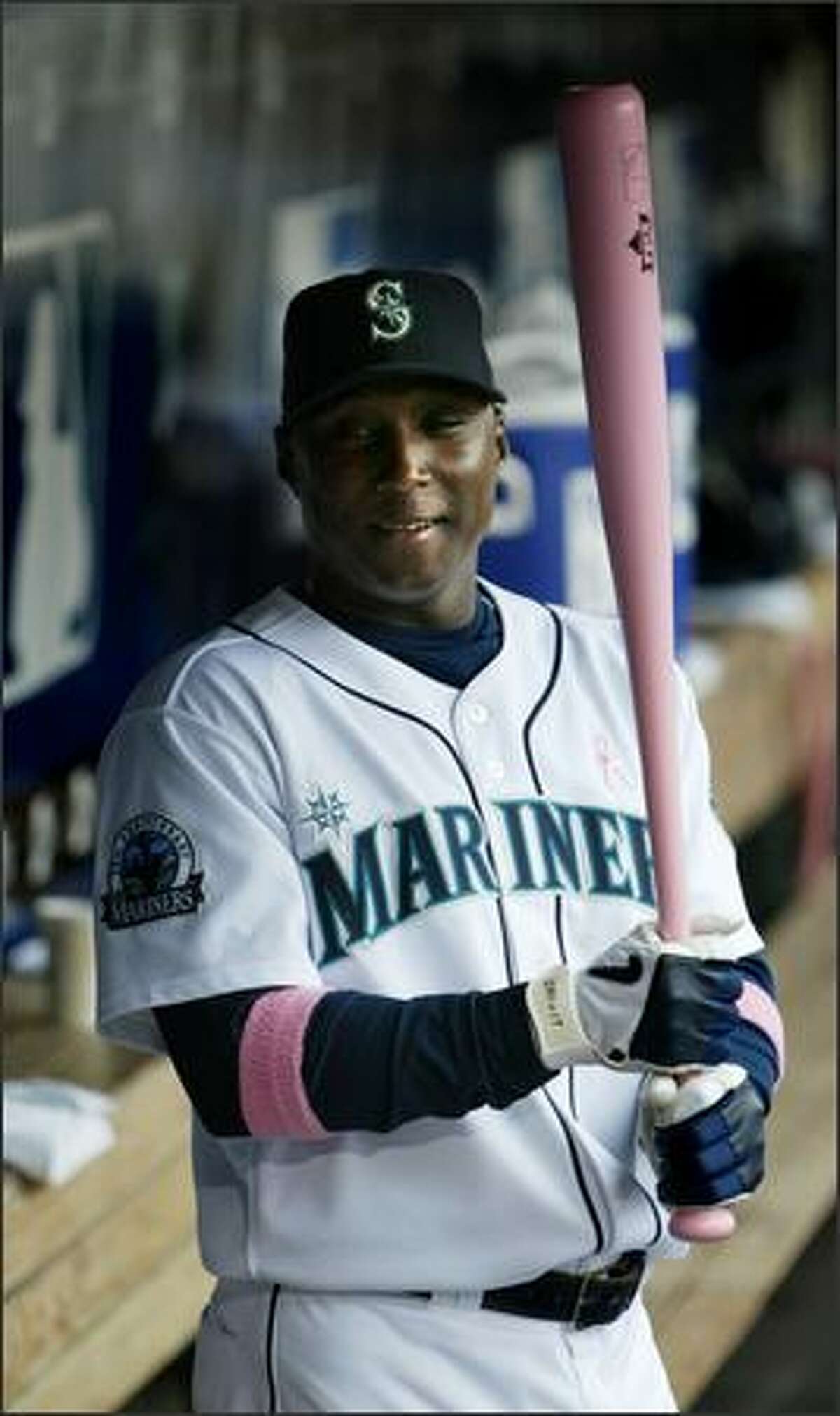 Before the game, Seattle Mariners shortstop Yuniesky Betancourt holds one of the pink bats he and other players used to support breast cancer awareness.
