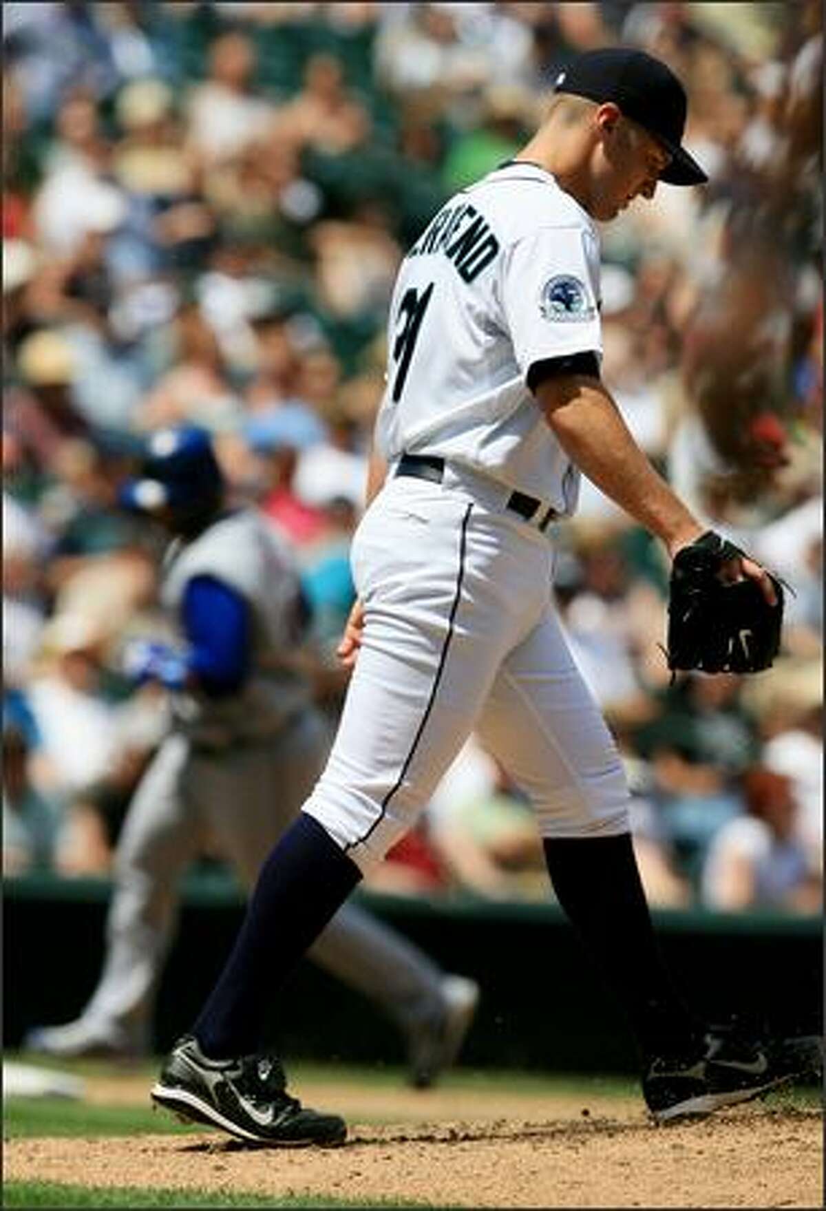 Seattle Mariners starter Ryan Feierabend heads back to the mound after giving up a three-run homer to Texas Rangers Victor Diaz, background, during the 4th inning. Feierabend recovered, throwing 7 and 1/3 innings, to register his first major league win.